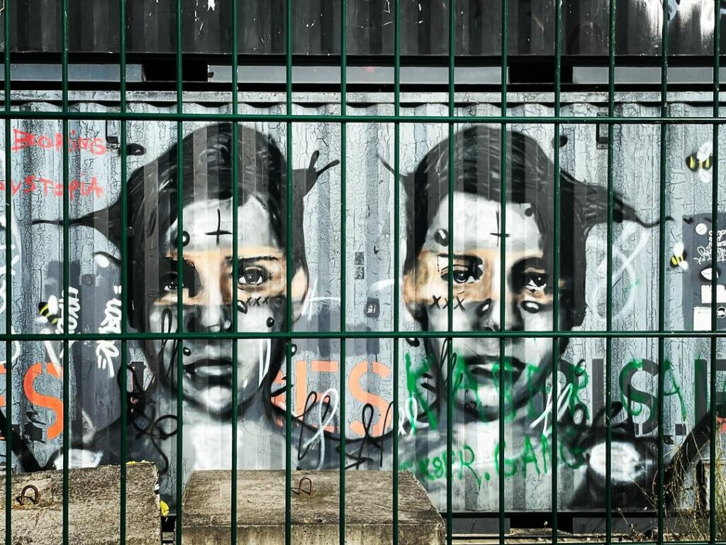 Peinture de deux visages juvéniles sur un container à Pantin, en 2023