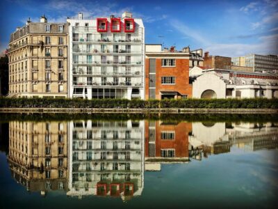Immeuble se reflétant dans l'eau au croisement du canal de l'Ourcq et du canal Saint-Denis